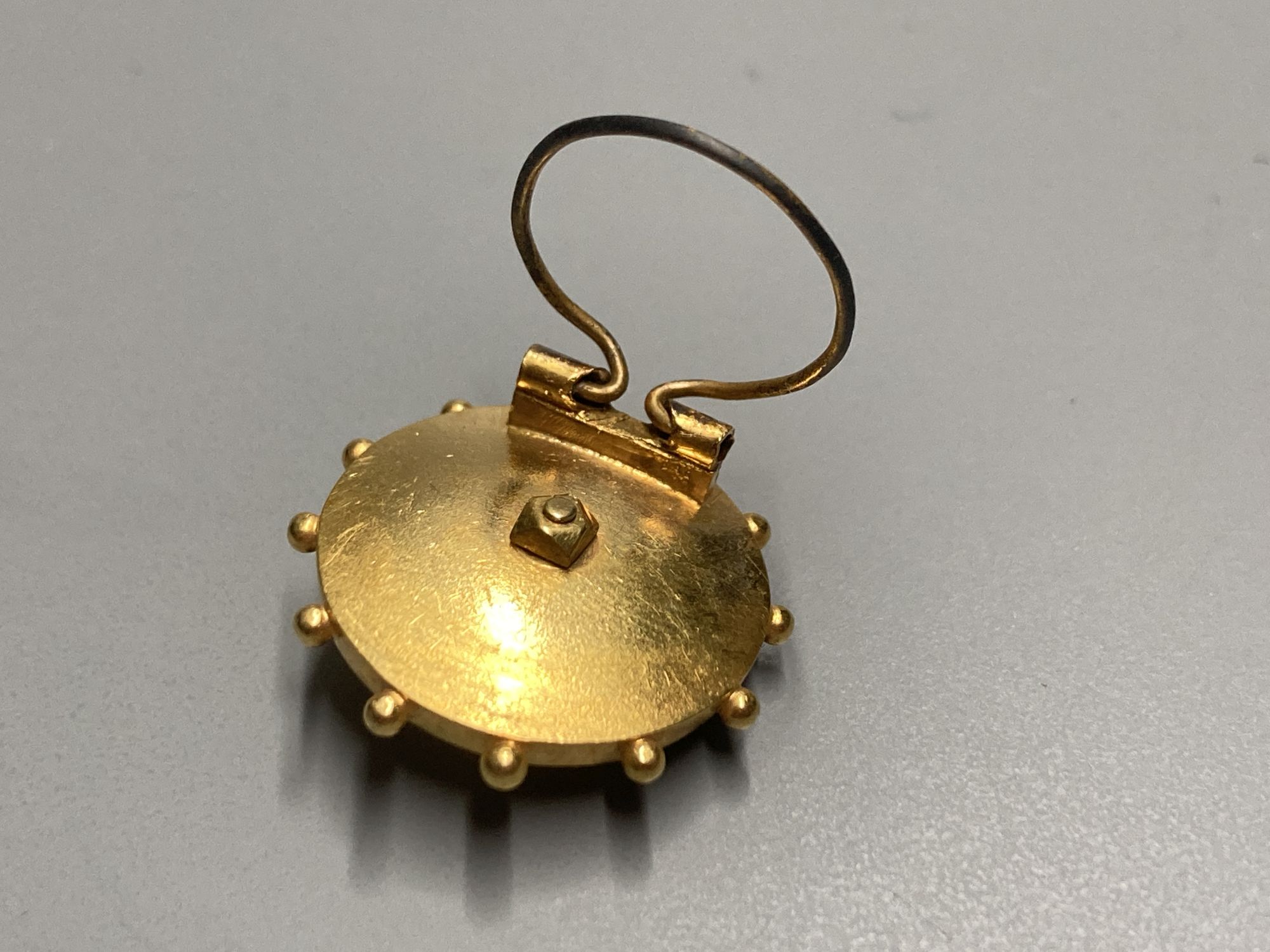 A late Victorian yellow metal and turquoise set circular brooch?? (now with wire for ear clip??), 17mm, gross 2.9 grams.